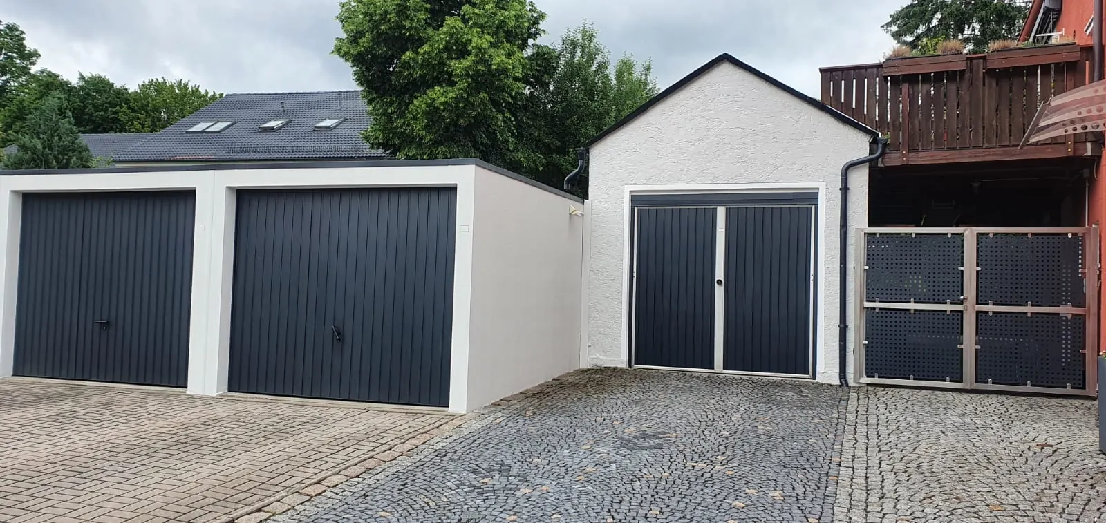 Garagen mit frisch gestrichener heller Fassade und dunklen Toren