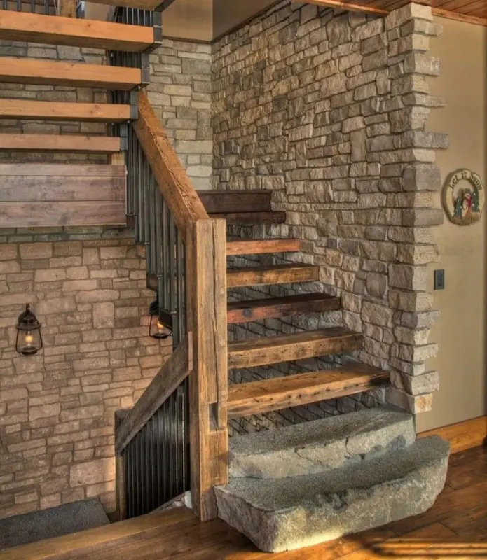 Treppe mit Holzstufen vor einer Natursteinwand